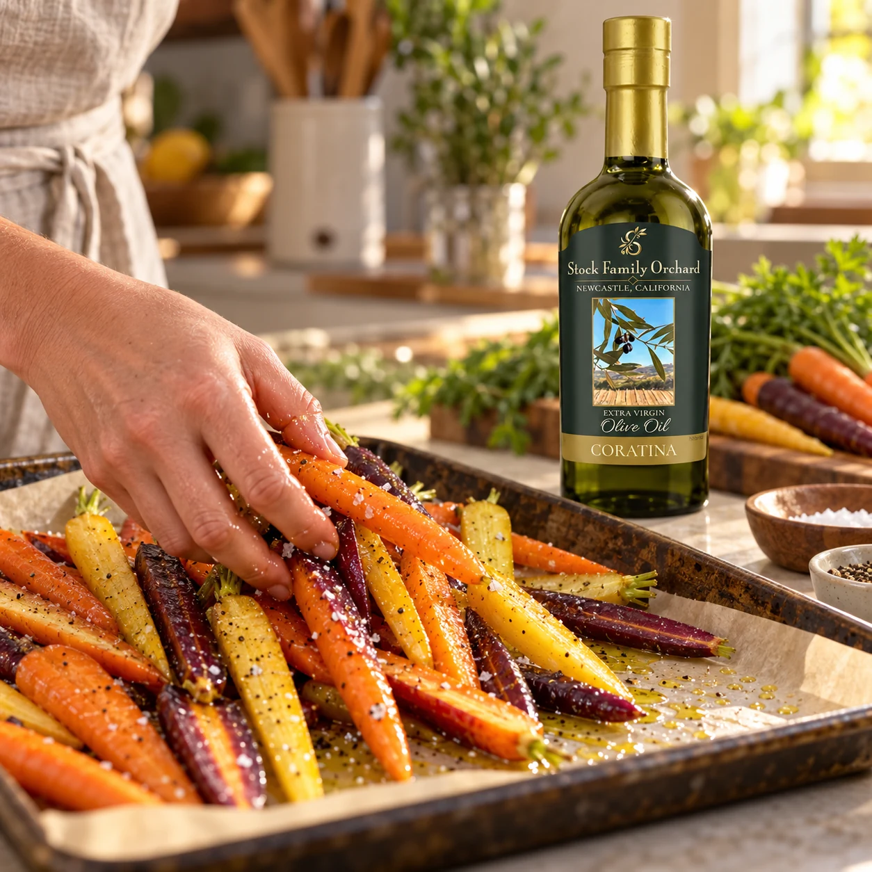 Stock Family Orchard Coratina bottle beside carrots tossed with olive oil before roasting